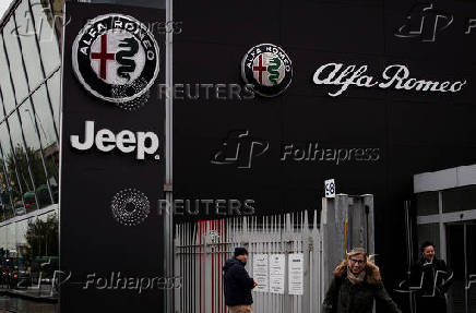 Car logos are displayed on the exterior of a car dealership