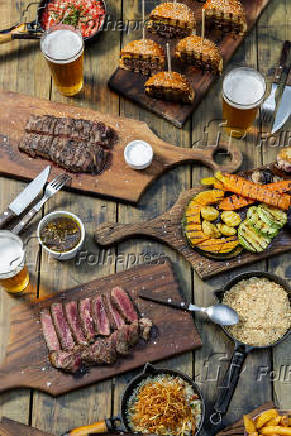 Mesa com churrasco, cerveja e outras alimentaes na churrascaria Quintal DeBetti