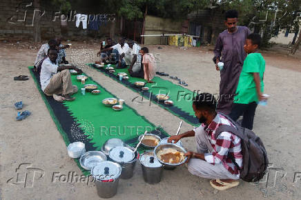 Displaced Sudanese prepare to break their fast at a displacement camp during the month of Ramadan, in the city of Port Sudan