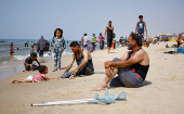 Palestinians enjoy the beach on a hot day, in Rafah