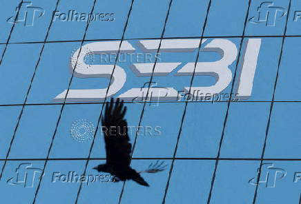 FILE PHOTO: A bird flies past the new logo of the Securities and Exchange Board of India (SEBI) at its headquarters in Mumbai