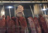 A butcher holds a piece of meat at a butcher shop in Rio de Janeiro