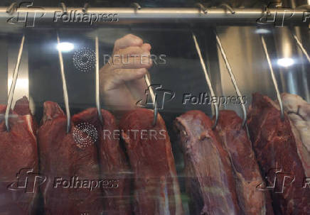 A butcher holds a piece of meat at a butcher shop in Rio de Janeiro