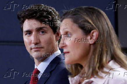 FILE PHOTO: Canada's PM Trudeau listens to Foreign Minister Freeland during news conference in Ottawa