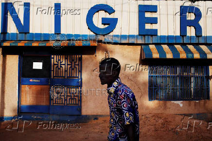 FILE PHOTO: A man walks past a sign reading 