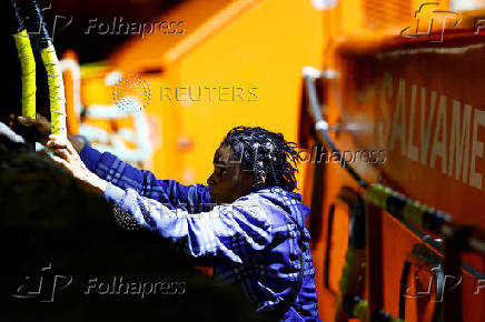 A migrant disembarks from a Spanish coast guard vessel, in the port of Arguineguin, on the island of Gran Canaria