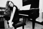 Claudia Riccitelli ao lado do piano.