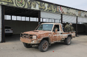 Rebel fighters sit at the back of a vehicle in Homs countryside