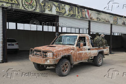 Rebel fighters sit at the back of a vehicle in Homs countryside