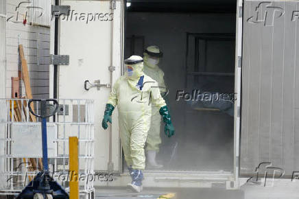 Funcionrio do hospital Joo Lcio retira corpo de paciente morto, em Manaus