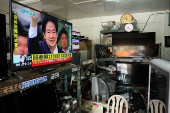 A live news broadcast shows Taiwan's new President Lai Ching-te wave, in Taipei