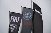 Car logos are seen on banners hung outside a car dealership