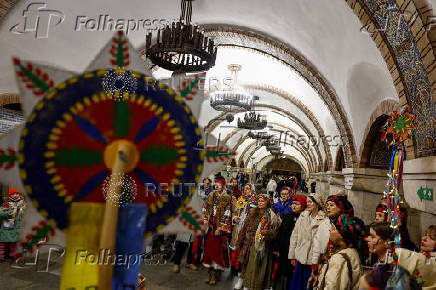 People dressed in traditional clothes sing carols inside a metro in Kyiv