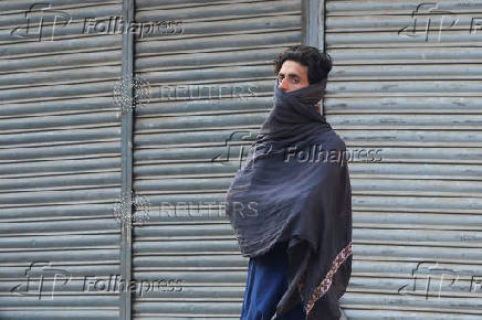 Labourer covers himself with a shawl, in Karachi