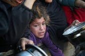 Palestinians gather to receive food cooked by a charity kitchen, in Khan Younis