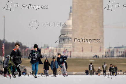 People skate on the ice-covered Lincoln Memorial Reflecting Pool on the National Mall, in Washington