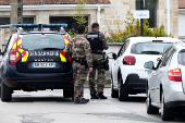 A member of the French Gendarmerie talks with a driver of a passing car in Wimereux