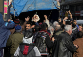 People gather around a truck to receive bread in Aleppo