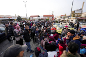 Syrians gather as they attempt to cross into Lebanon, at the Masnaa border crossing between Lebanon and Syria