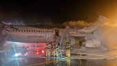 Firefighters try to put out the fire from an Air Busan plane at Gimhae International Airport in Busan