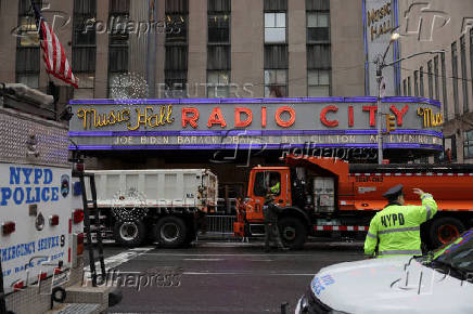 Officers from the New York City Police Department (NYPD) stand guard beside trucks from the New York City Department of Sanitation outside Radio City Music Hal