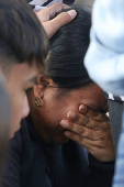 Migrants comfort a woman at El Chaparral border crossing after their CBP One app asylum appointment was cancelled on the day of U.S. President Donald Trump's inauguration, in Tijuana