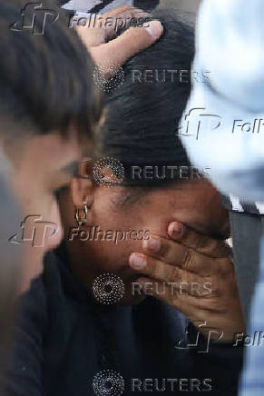 Migrants comfort a woman at El Chaparral border crossing after their CBP One app asylum appointment was cancelled on the day of U.S. President Donald Trump's inauguration, in Tijuana