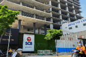 FILE PHOTO: A logo of Saigon Joint Stock Commercial Bank (SCB) is seen in front of an under-construction building in Ho Chi Minh City