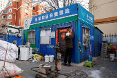 Wu puts on couplets to decorate a recycling station in Beijing