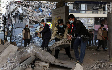 Members of Imam al-Mahdi scouts clean rubble and debris from damaged buildings in Beirut's southern suburbs