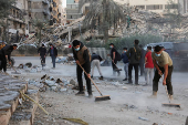 Members of Imam al-Mahdi scouts clean rubble and debris from damaged buildings in Beirut's southern suburbs