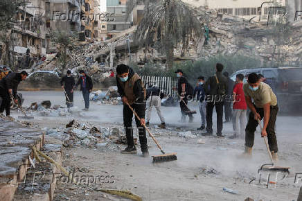 Members of Imam al-Mahdi scouts clean rubble and debris from damaged buildings in Beirut's southern suburbs