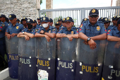 Police standby outside the Villamor Airbase where former Philippine President Rodrigo Duterte is currently held after being arrested