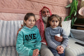 Akram Shalbout, a Syrian living in Jordan, sits with his family, in Irbid