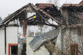 A firefighter works at a damaged nursing home that caught fire, outside Belgrade