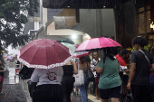 Pedestres enfrentam chuva na Avenida Paulsita, em So Paulo (SP)