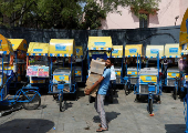 An ice cream vendor carries boxes of ice creams to load onto his cart on a hot summer day in New Delhi