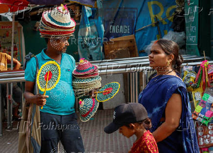 A vendor sells bamboo fans and hats outside Alipore Zoological Garden on a hot summer day in Kolkata