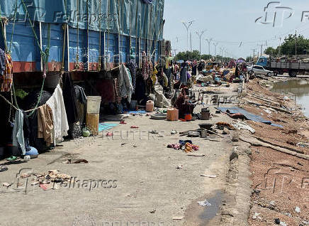 People take refuge along an expressway after relief camps reached maximum capacity in Maiduguri