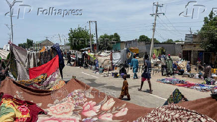 People take refuge along an expressway after relief camps reached maximum capacity in Maiduguri