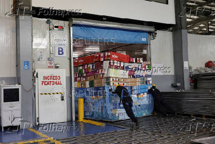 Workers handle boxes of flowers for export before Valentine?s Day, in Quito