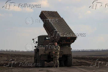 Ukrainian serviceman stands next to a Grad MLRS before firing it towards Russian troops near a front line in Donetsk region
