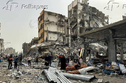 Palestinians inspect the damages following an Israeli raid in Nuseirat, in the central Gaza Strip
