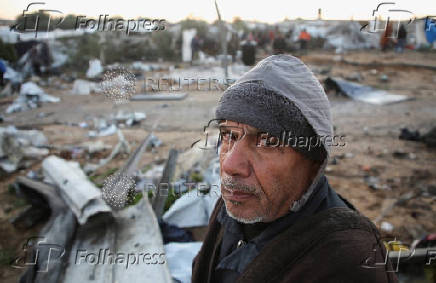 Palestinians inspect the damage at a tent camp sheltering displaced people, in Khan Younis