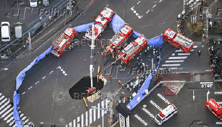 An aerial view shows rescue operations underway at a large sinkhole that swallowed a truck at an intersection in Yashio