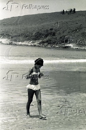 Banhista ajeita biquni em praia no