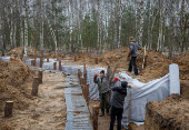 Workers build a trench as part of a system of new fortification lines near the Russian border in Chernihiv region