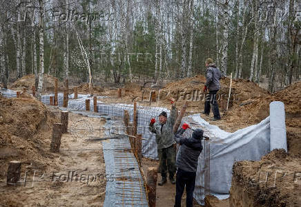Workers build a trench as part of a system of new fortification lines near the Russian border in Chernihiv region