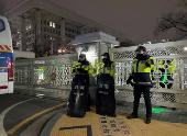 Policemen stand in front of the gate to the National Assembly after South Korean President Yoon Suk Yeol declared martial law in Seoul