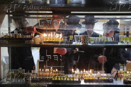 Ultra Orthodox Jews light Hanukkah holiday candles in Jerusalem